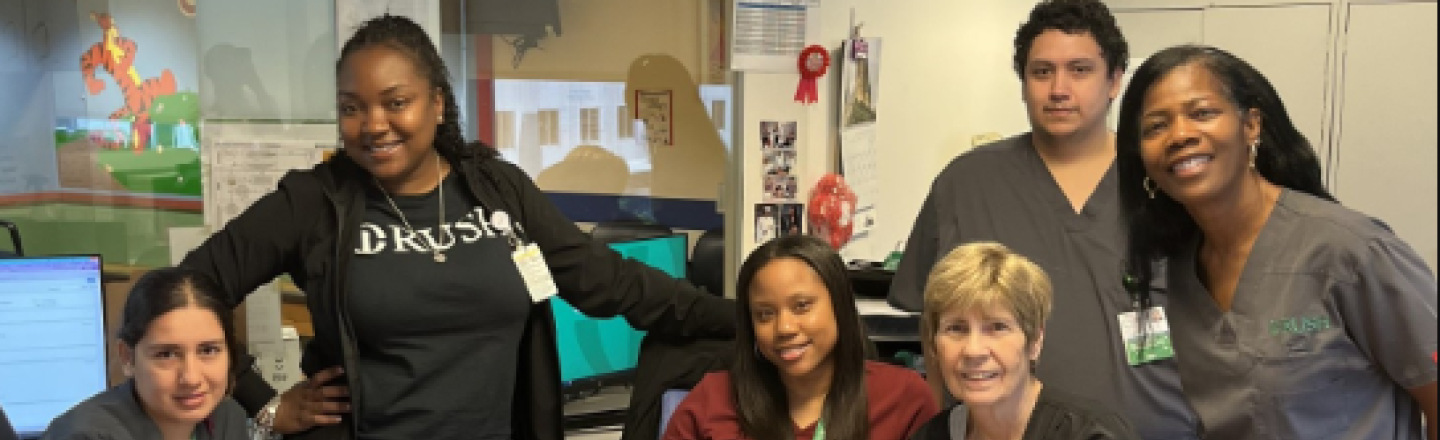 Six Lifetime Medical Associates staff members gather in an office space wearing RUSH scrubs and gear.