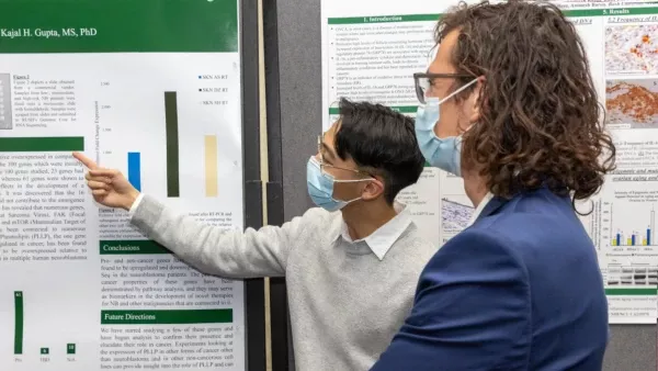 A researcher gestures to a poster