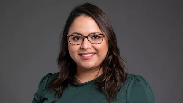 Head shot of Susan Lopez, MD, wearing a green short and glasses and smiling at the camera