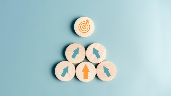 5 wooden circles with painted blue or orange arrows pointing towards circle with painted target